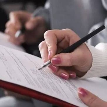 Eine Hand füllt mit einem Stift ein Formular aus